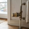 Gammel radiatorventil på en hvid radiator i et dansk hjem